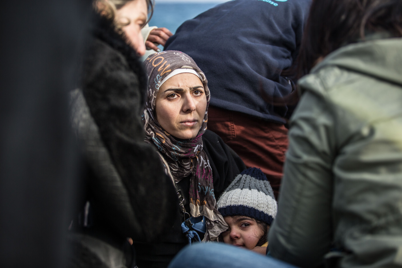 Greece. Female refugee sits with child