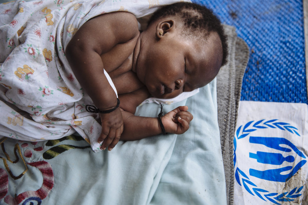 Une petite fille sud-soudanaise d’un mois dort sur une natte dans le village de réfugiés de Bidibidi, en Ouganda. © HCR/David Azia