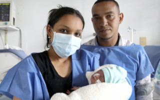 Parents from Venezuela hold their newborn baby