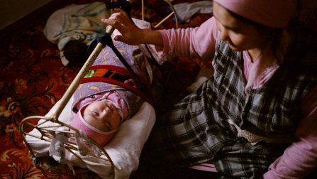 Een vrouw schommelt haar acht maanden oude baby in zijn wieg, Tastubek, Kazachstan. © Laurent Weyl/Panos Afbeeldingen