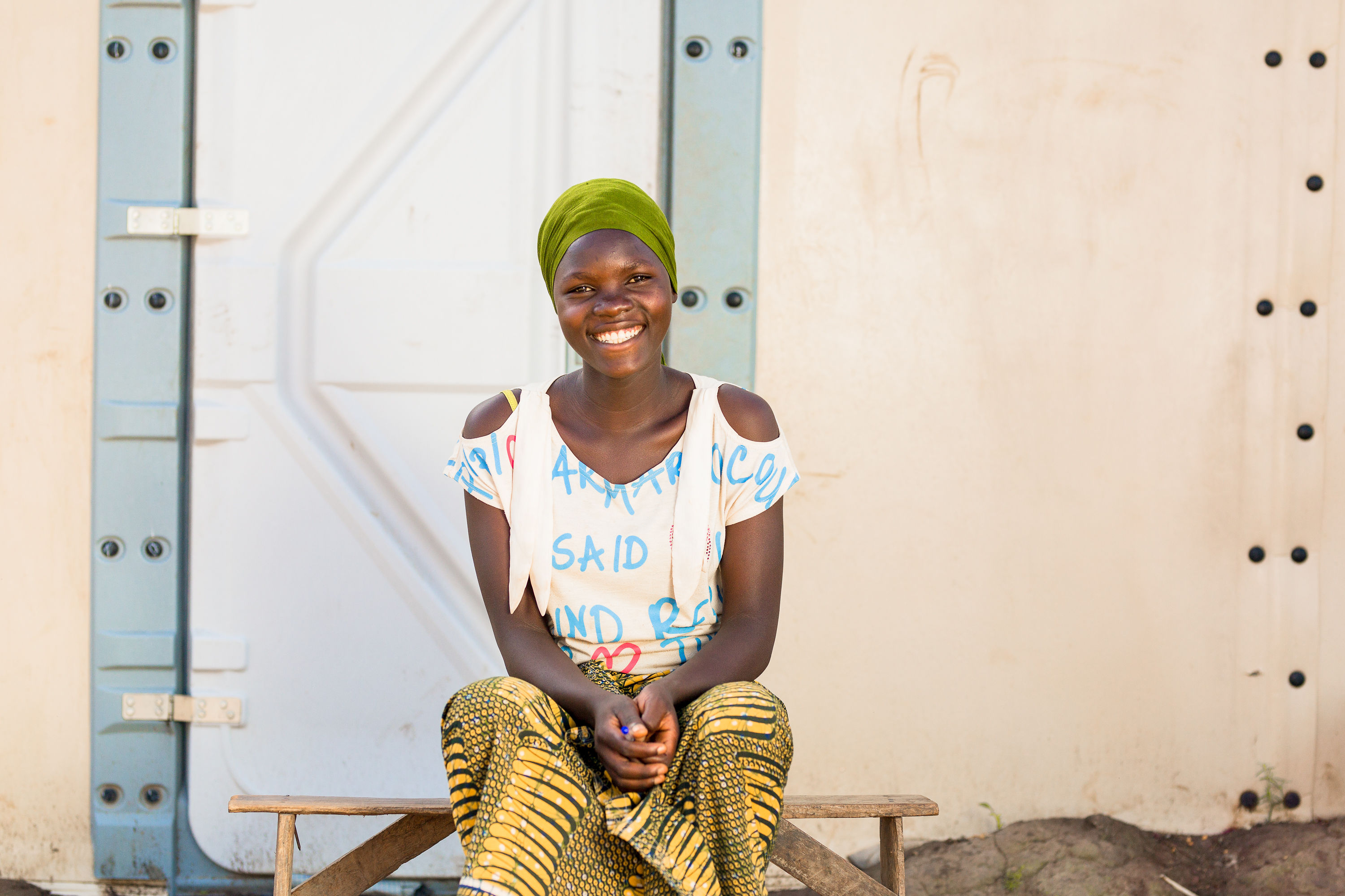 Velarie Ntahonicaye voor het huis van haar en haar familie in het Kigoma kamp in Tanzania.