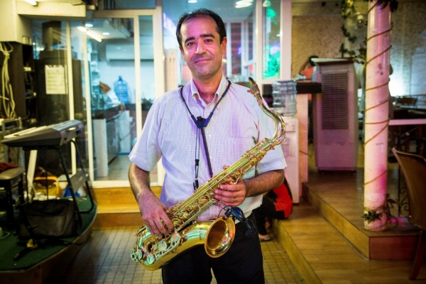 Nader with his saxophone at a restaurant in Bangkok, where he performs every night. ©UNHCR/R. Arnold/2015