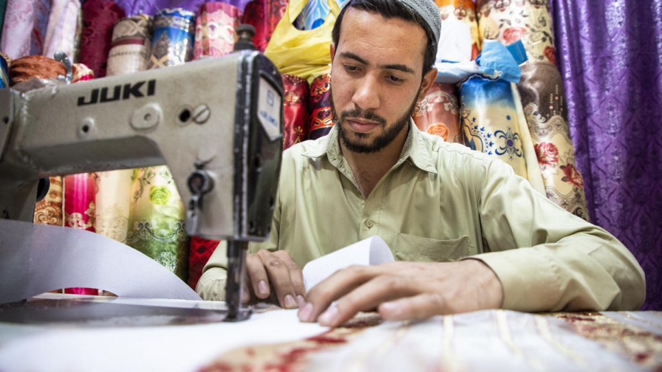 Shifat Ullah, 23, at his fabrics shop in Al-Asif Square market in Karachi.