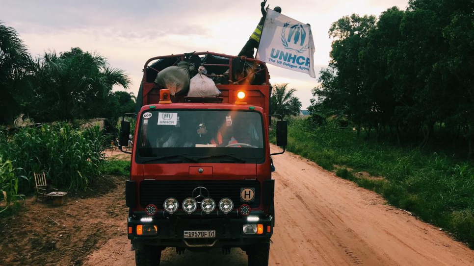 A Congolese repatriate waves the UNHCR flag as he arrives in Kananga, capital of the Kasai Province, after years spent as a refugee in Angola.