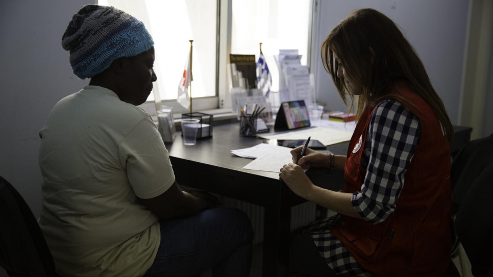 Nakout talks to the a women from people-tracing service in the office of the Greek Red Cross. Her children and sister thought she was dead. They are alive and living in Uganda.