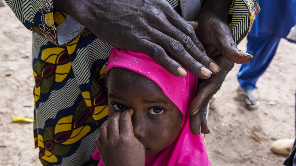 Djenika, in a pink headscarf,  and her father Zana, are among villagers without papers in Olleo, Côte d'Ivoire.