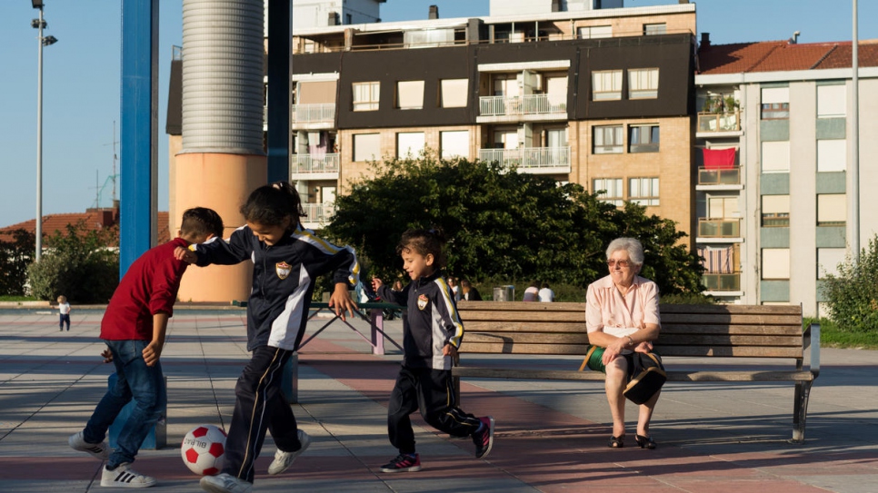 "People say to me, 'What are you doing helping those peoplep' and I say, 'It is more what they are doing for me!'" Begoña Herrero, a local volunteer, watches the sponsored family's children as they play football in a park in Portugalete, Spain.