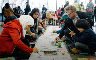 Volunteers paint with refugee children at the Hauptbahnhof train station in Vienna.