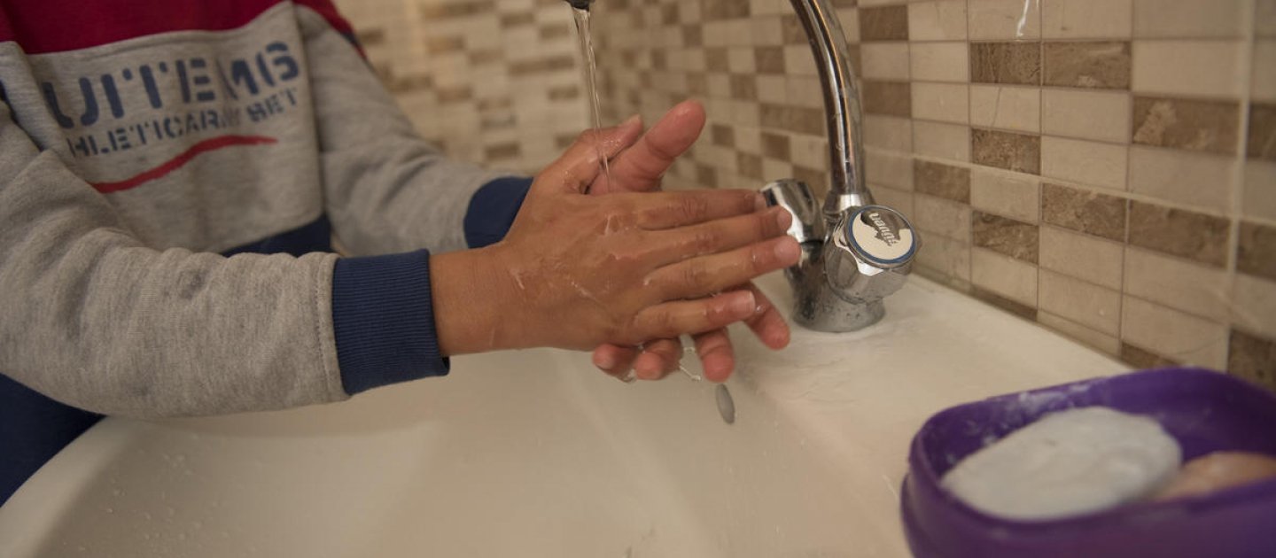 Jordan. Qusai (11) washes his hands in the sink at home