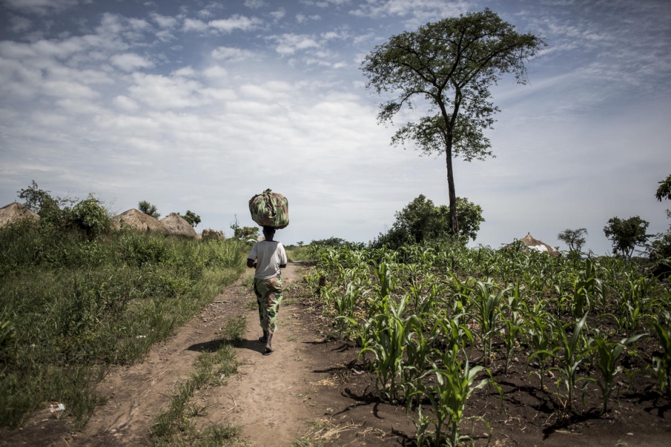 Neema transporta una bolsa de berenjenas recolectadas en la tierra que trabaja con agricultores locales y refugiados. 