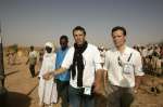 A UNHCR programme officer explains to UNHCR Goodwill Ambassador Julien Clerc how the UN refugee agency cares for Sudanese refugees from the Darfur region once they arrive at the temporary site of Mahamata in eastern Chad. March 2, 2004.