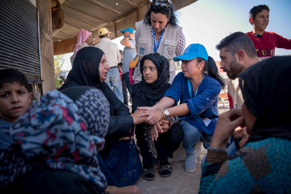 A UNHCR staff comforts a mother in Rasem Alharmal, a small village in rural Aleppo with a pre-crisis population of 1,500 people. Around 1,000 have returned since fighting ended in April 2017. Most found their houses destroyed and looted.
