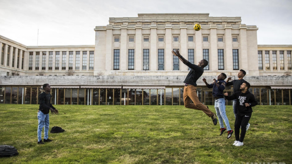 Refugees and asylum-seekers attending events during the Global Refugee Forum play football on the lawn at the Palais des Nations.
