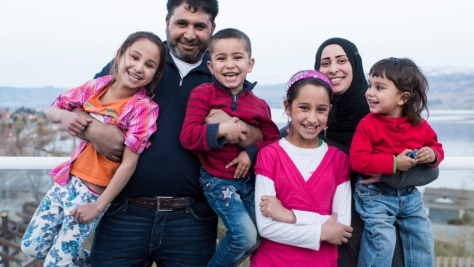 Canada. Mohammad, a Syrian refugee, poses on the balcony of the house his sponsors have rented for him and his family. Also in the photo are his wife Sahar and their four children