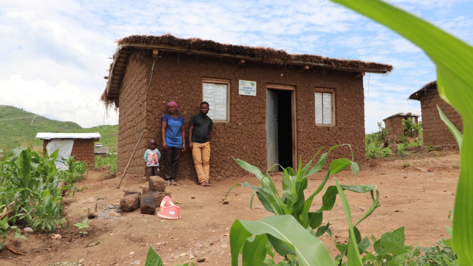 Burundian refugee Aisha, her child and her husband Matias stand outside their house in Mulongwe settlement, Democratic Republic of the Congo.

