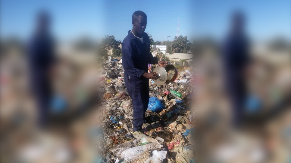 Sudanese refugee Mohammed looks for recyclables at a waste landfill in southern Tripoli, Libya.