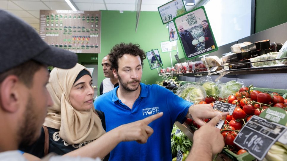 Stefano Specchia, de la Fédération des Eglises Evangéliques, montre à Hanadi, 39 ans et réfugié palestinien de Syrie, comment les supermarchés italiens étiquettent les légumes.