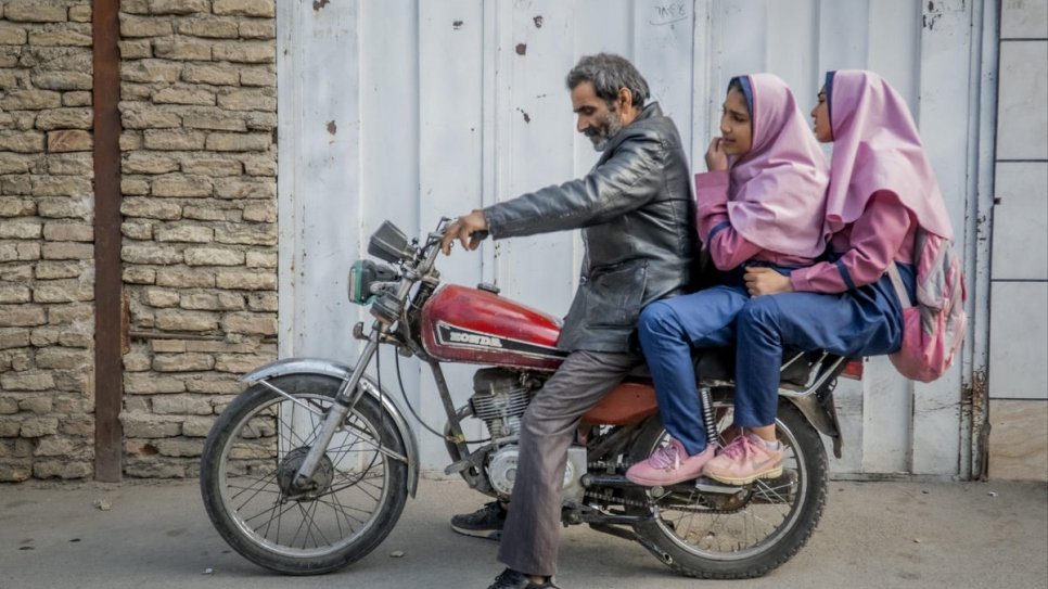Besmellah, réfugié afghan, conduit ses filles Parisa, 16 ans, et Parimah, 14 ans, à l'école, à 10 kilomètres de leur domicile à Ispahan, en Iran.