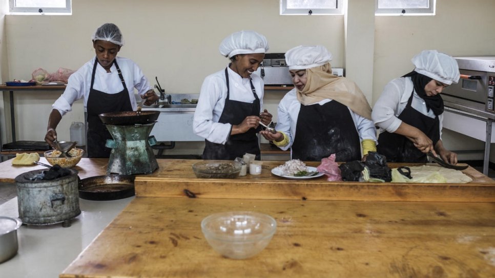 Hanan, une réfugiée yéménite, et son amie éthiopienne, Yanchinew (au centre) préparent des plats dans le cadre d'un cours de cuisine au Nefas Silk Polytechnic College à Addis Abeba, Ethiopie.