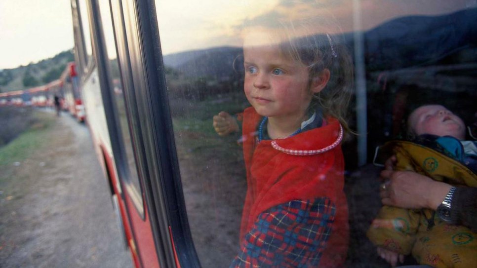 Une jeune réfugiée kosovare* regarde par la fenêtre d'un train en partance pour l'aéroport de Skopje. Sa famille a été relocalisée en Allemagne en juin 1999 au titre du programme d'évacuation humanitaire. 