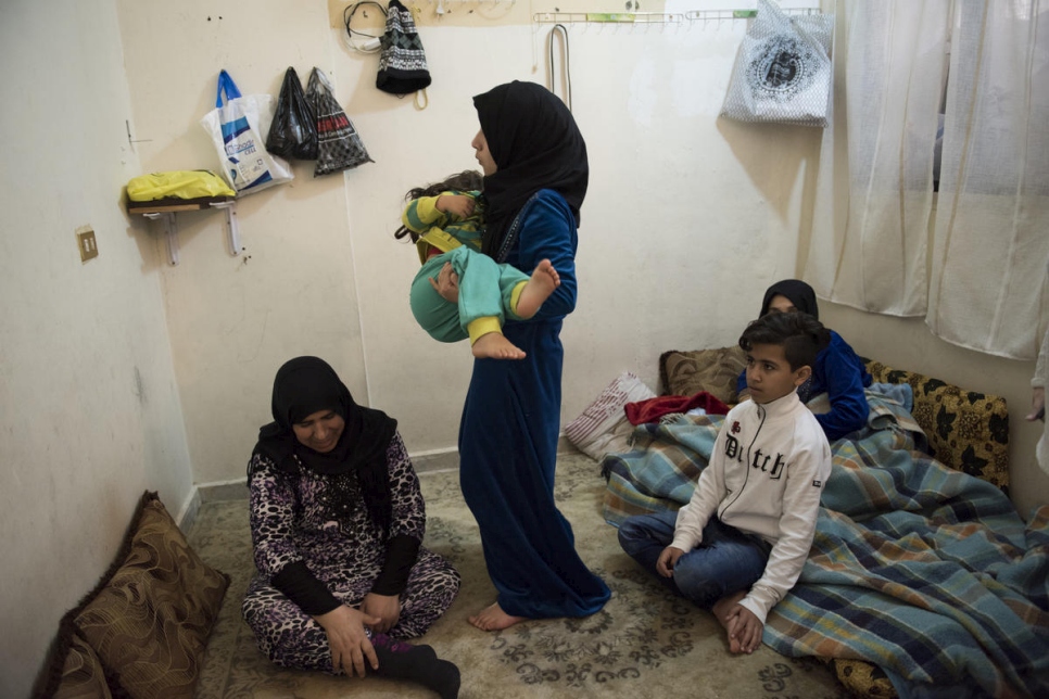 Kutna, réfugiée syrienne, est assise parmi ses proches dans la chambre où ils vivent au sein d'un immeuble d'habitation au Mont-Liban, au Liban. 