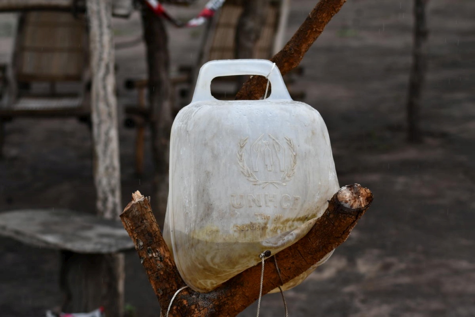 Le jerrycan rempli d'eau est fixé sur un tronc d'arbre dans la cour de Ferida au site de Bele, en République démocratique du Congo. 