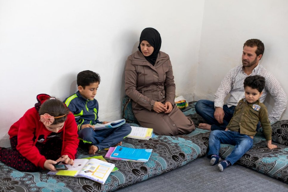 Le réfugié syrien Naeem (à droite) et sa femme Salwa (au centre) sont assis chez eux avec leurs enfants à Amman en Jordanie, pendant le confinement pour endiguer la pandémie de Covid-19.  