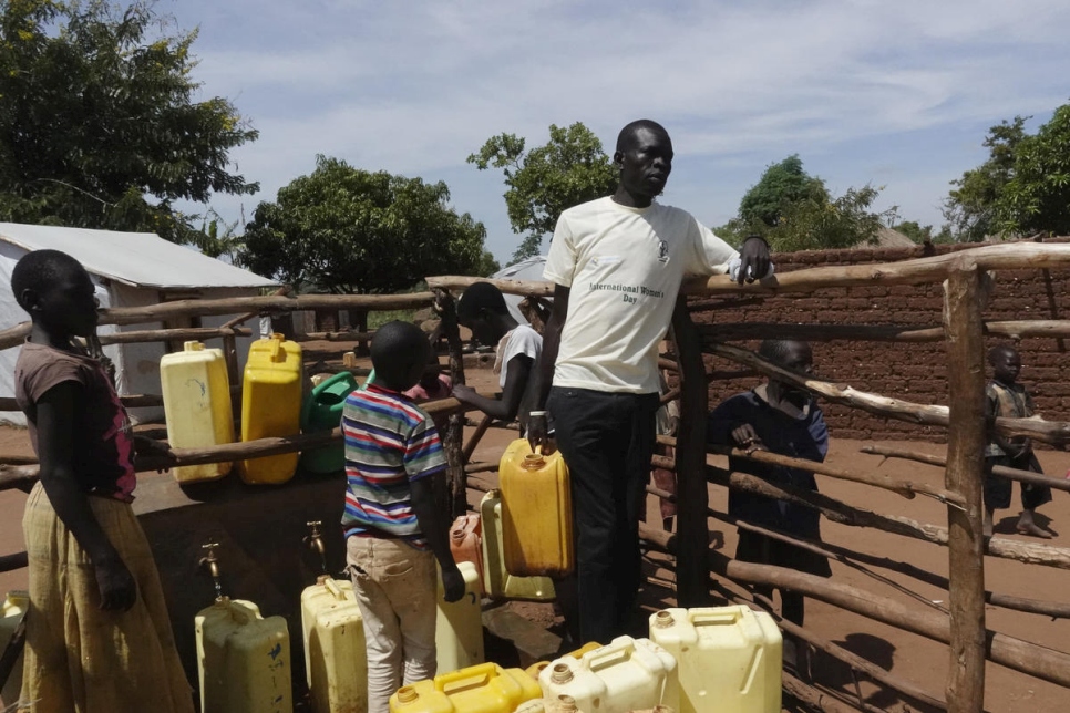 Abraham Bidal, de 32 años y proveniente de Yei, Sudán del Sur, está recolectando agua para regar los árboles que acaba de plantar alrededor de su casa. 