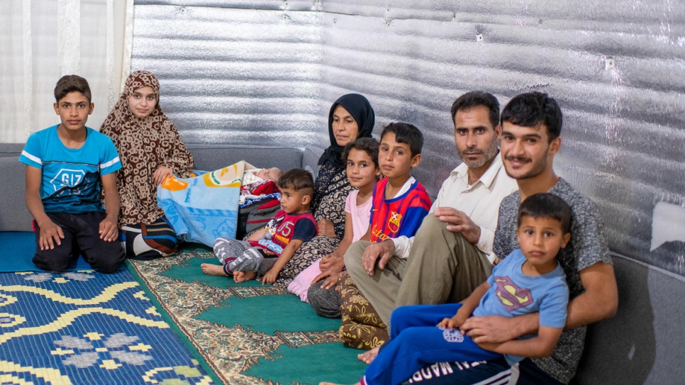 Le réfugié syrien Ahmad Hussain (troisième à partir de la droite) et sa famille dans leur abri au camp de réfugiés d'Azraq, en Jordanie.  