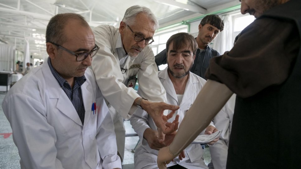 Le physiothérapeute italien Alberto Cairo (au centre) soigne un patient avec son équipe au centre de rééducation physique de Kaboul, en Afghanistan. 