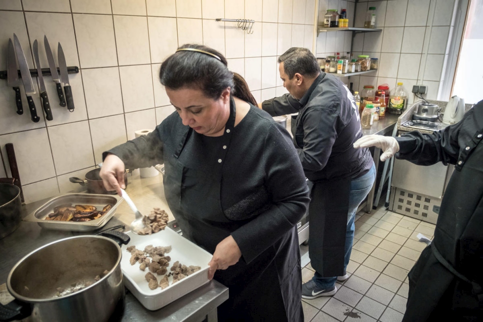 La refugiada siria Salma Al Armarchi cocina con un empleado en su cocina de Berlín, donde dirige su empresa, Jasmin Catering.