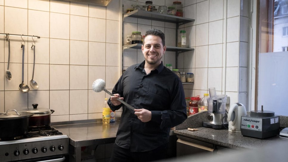 Syrian refugee Fadi Zaim, 32, in his mother Salma Al Armarchi's kitchen in Berlin, from where she runs her company, Jasmin Catering.