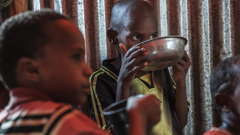 De jeunes réfugiés somaliens en train de manger dans une école de Vision du monde transformée en abri temporaire à Bur Amino, Éthiopie. 
