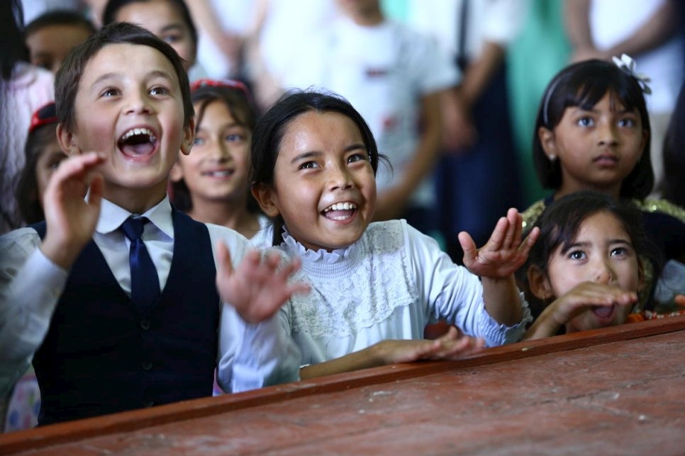 Des enfants regardent un spectacle de marionnettes à Vakhdat, au Tadjikistan, à l'occasion de la Journée mondiale 2019 du réfugié. 