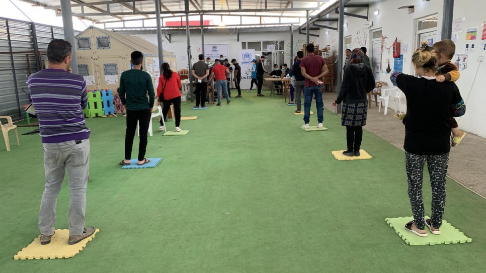 Refugiados sirios hacen fila para recibir ayuda financiera en un centro de ACNUR en el campamento de Duhok, en el Kurdistán iraquí.