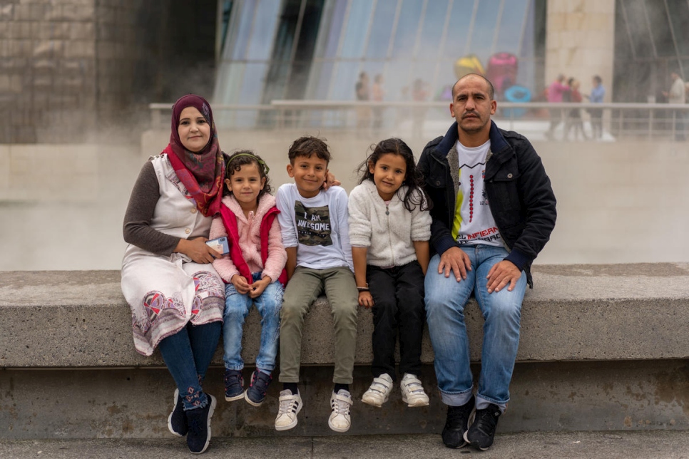 Wafaa, Mashael, Adnan, Sidra y Minwer delante del museo Guggenheim de Bilbao, durante un paseo con un grupo de voluntarios comunitarios.