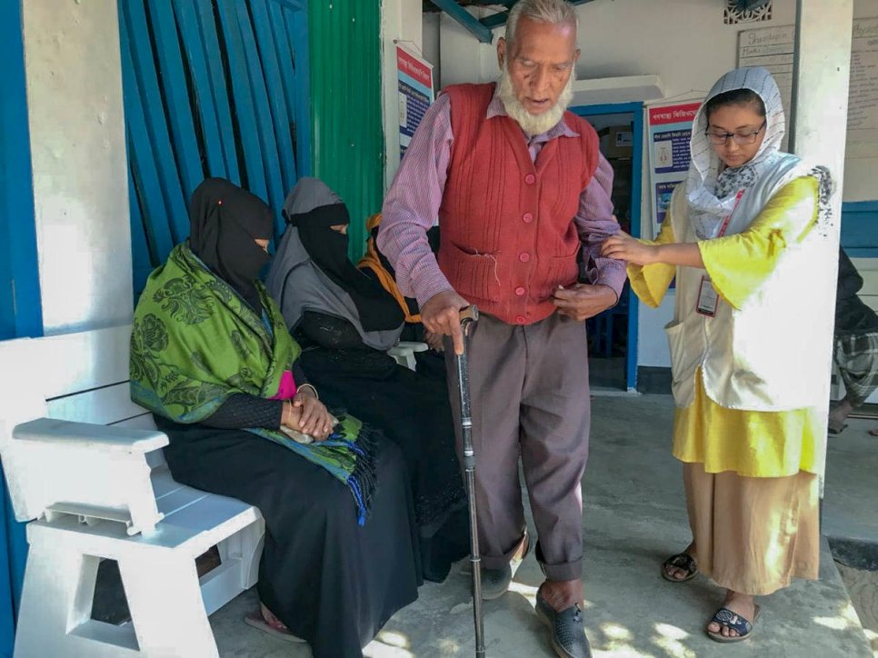 Naushin Anjum (der.) guía a su paciente Abdul Quddus en el Centro de Fisioterapia y Rehabilitación Física de Shamlapur (Bangladesh), financiado por ACNUR. 