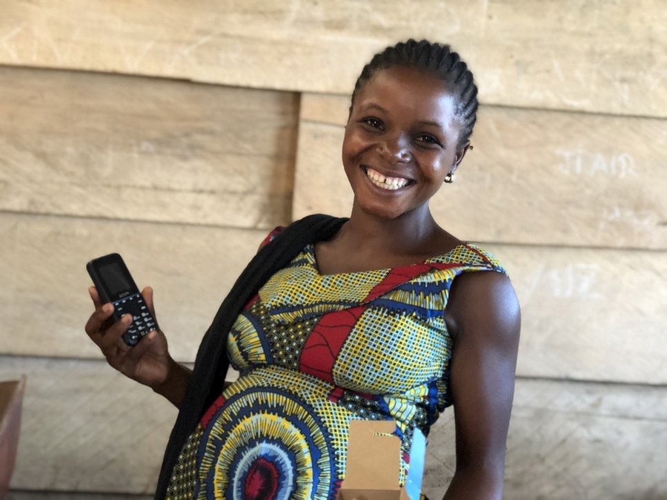 Jaëlle, 24 ans et déplacée congolaise, reçoit un téléphone mobile et une carte SIM dans la province du Nord-Kivu, où le HCR distribue des allocations d'aide en espèces par le biais des téléphones mobiles à des milliers de familles vulnérables. 