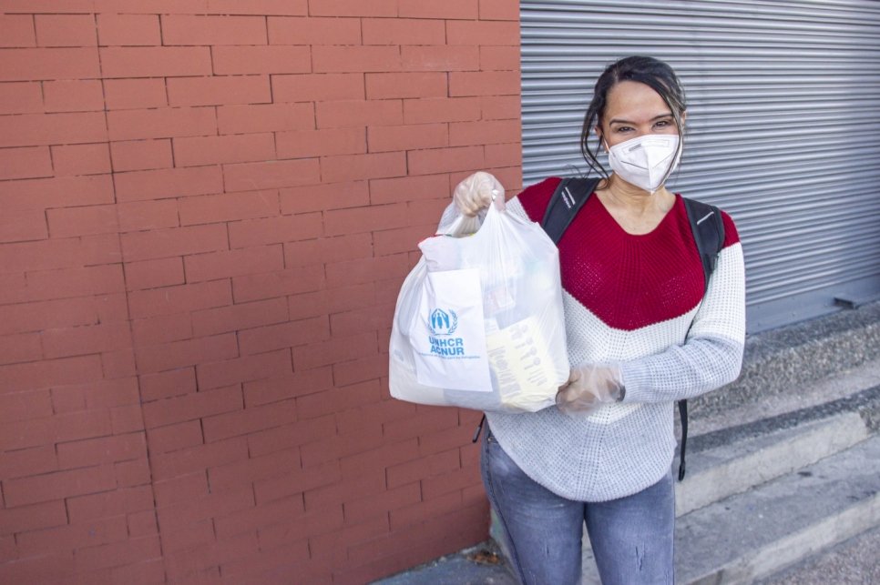 La pandémie a empêché Lorena, 37 ans, une Vénézuélienne déplacée à Quito en Équateur, de voir sa fille, même si elle vit dans la même ville. Elle partage son colis d'aide alimentaire avec ses voisins.    