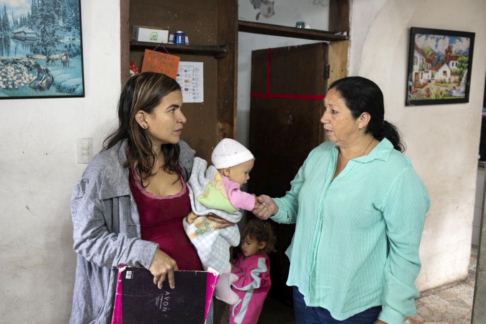 Marta Duque advierte a una mujer venezolana con sus hijos sobre las dificultades que podrían encontrar en su viaje por la montaña.