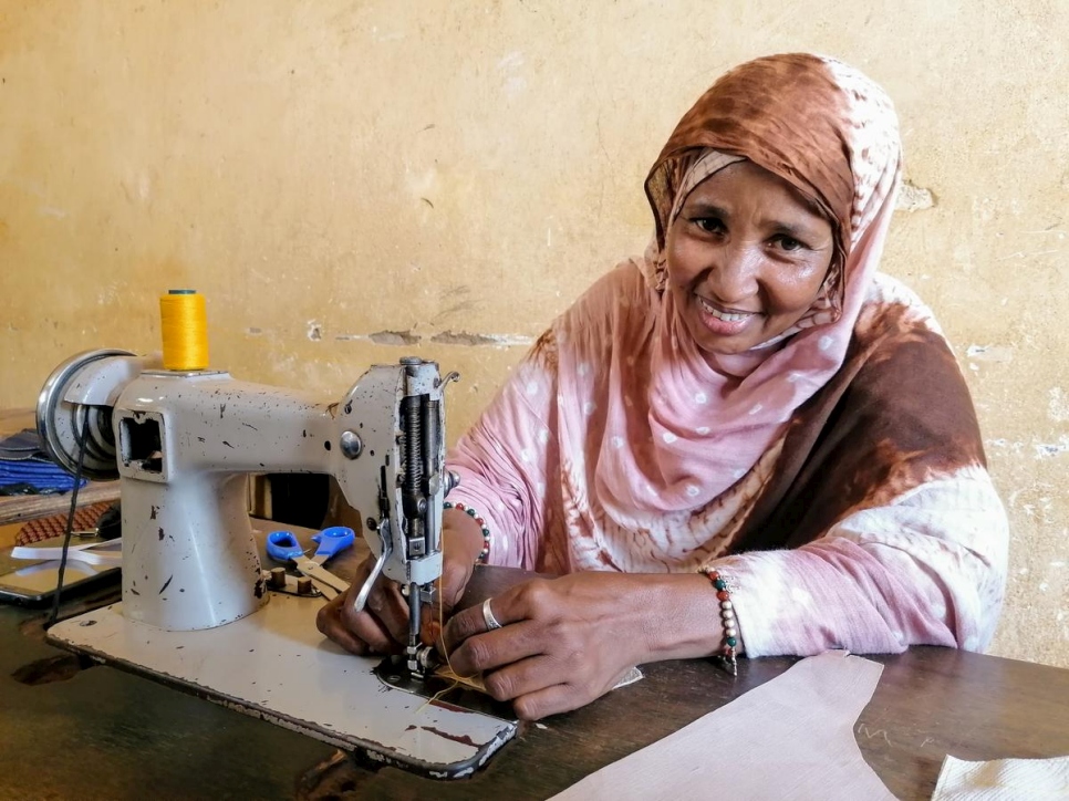 Fátima, una refugiada de Malí, usa una máquina de coser para hacer mascarillas en un taller en Niamey.