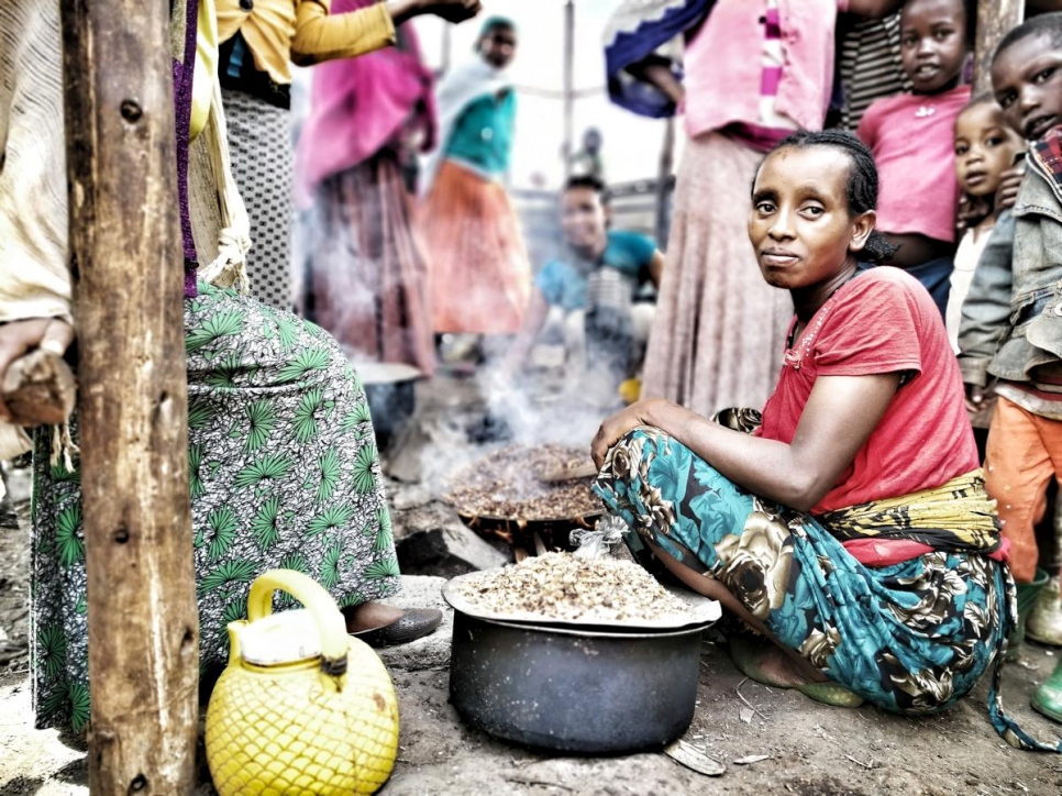 Una mujer de la comunidad gedeo cocina en un campamento para desplazados internos en Etiopía. 
