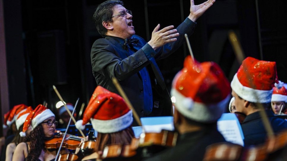 Víctor Mata, chef d'orchestre d'origine vénézuélienne, en train de diriger l'Orchestre philharmonique du Panama durant un concert de Noël consacré aux réfugiés et aux demandeurs d'asile. 