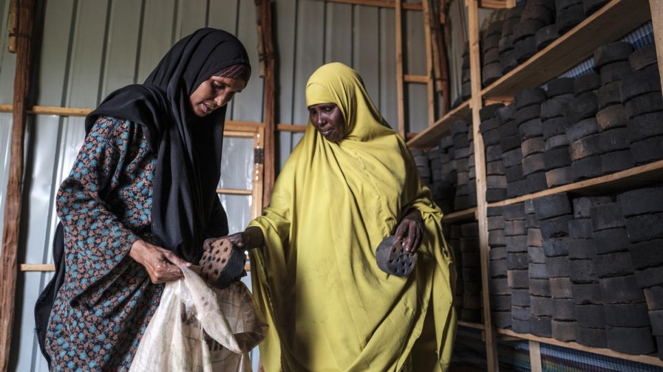 Asha Abdikadir Ahmed (à gauche), une réfugiée somalienne de 42 ans, achète des briquettes de charbon de bois au centre de production à Bur Amino, en Éthiopie. 