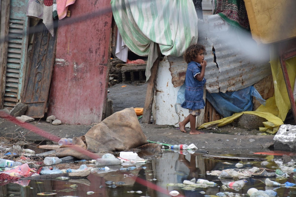 Un menor camina entre los charcos de agua estancada fruto de las inundaciones en un asentamiento para personas desplazadas internas en Aden, Yemen, en marzo de 2020.