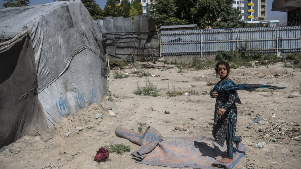 A child walks through a camp for internally displaced people in the Afghan capital, Kabul, July 2019.