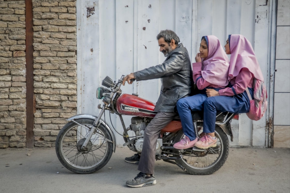 Besmellah, refugiado afgano, lleva a la escuela a sus hijas Parisa, de 16 años, y Parimah, de 14. Dista 10 kilómetros de su hogar en Isfahán (Irán).