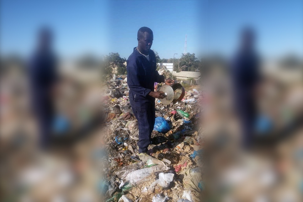 اللاجئ السوداني محمد يبحث عن مواد قابلة لإعادة التدوير في مكب للنفايات في جنوب طرابلس، ليبيا.