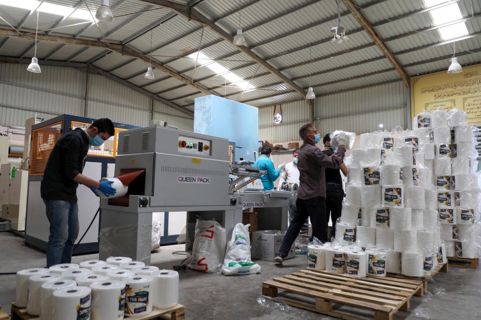 موظفون، بمن فيهم لاجئون سوريون، يحزمون الأقمشة في مصنع الخمائل في ضاحية سحاب في عمّان، الأردن.