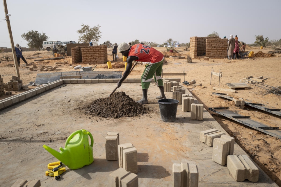 عمال بناء يمثلون كلا من اللاجئين والمجتمعات المضيفة يبنون أول منزل من المنازل الـ 1,000 في قرية ولام، تيلابيري، جنوب غرب النيجر. 